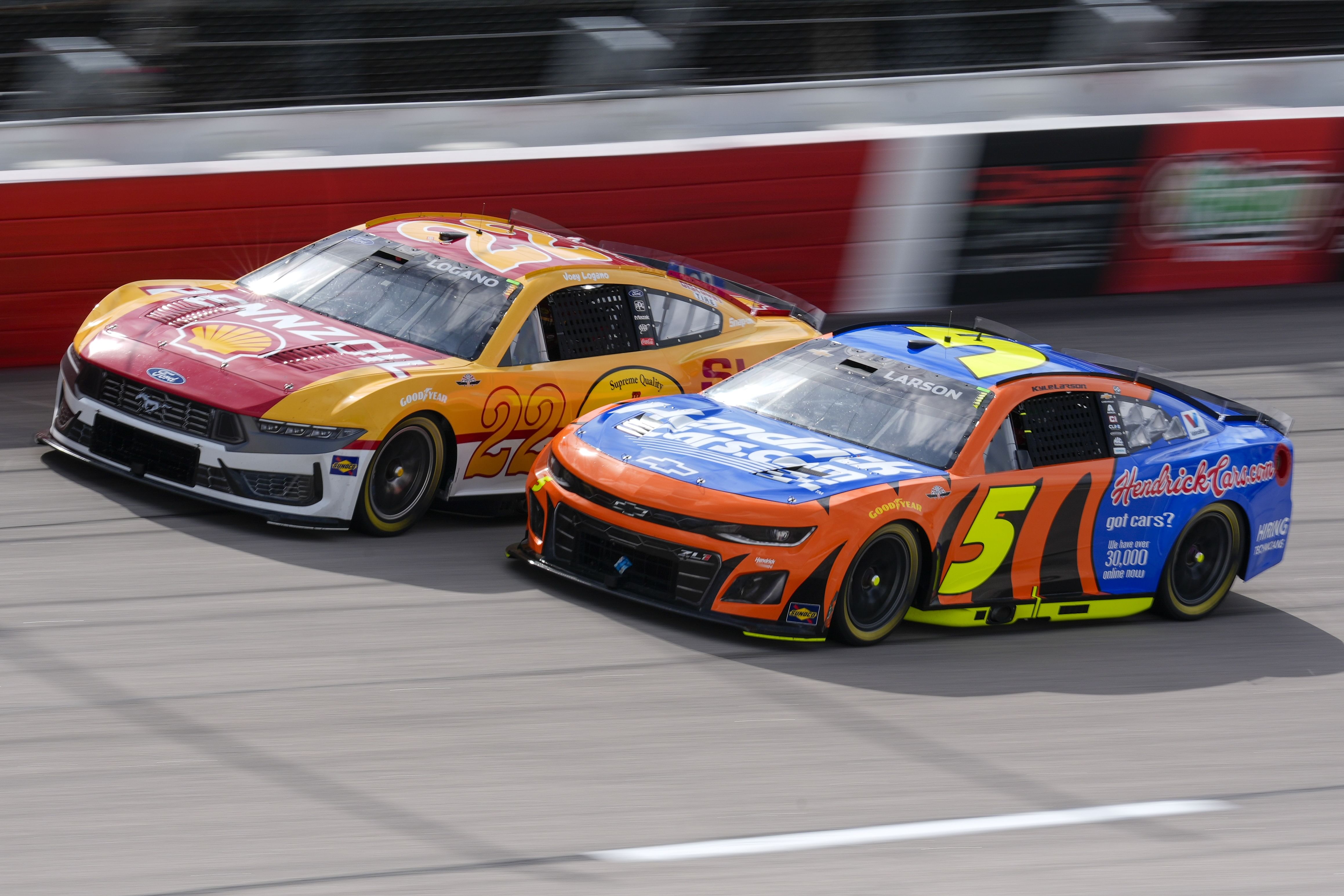 Joey Logano (22) and driver Kyle Larson (5) race out of turn four during the Goodyear 400 at Darlington Raceway. - Source: Imagn